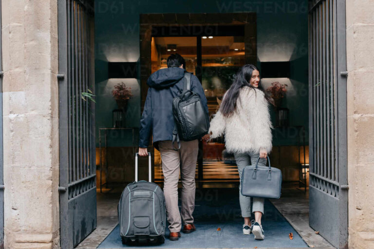 back-view-of-happy-stylish-young-couple-in-love-with-suitcase-and-bags-holding-hands-and-entering-modern-city-hotel-during-travel-while-woman-looking-at-camera-over-shoulder-adsf14471-768x512 Главная